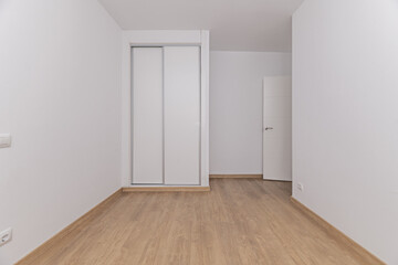 Bedroom with separate twin beds, white painted walls and built-in oak wardrobe