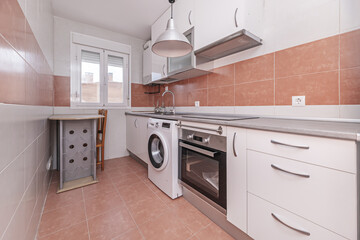 Fototapeta premium Kitchen with combined white and light brown tiles, white furniture and gray countertop