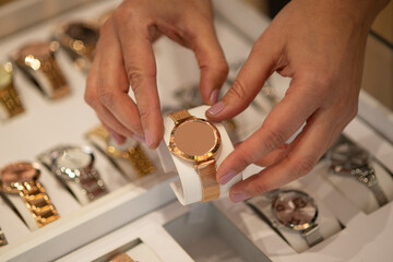 Woman's hands arranging a display of female wristwatches on a store display