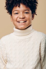 Young african american boy with bright smile wearing a white turtleneck sweater against a soft beige background