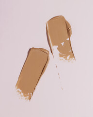 Makeup foundation, beige concealer swatch smudge smear on pink background. BB CC cream texture