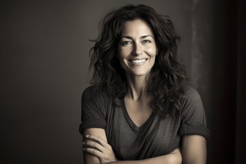 Naklejka premium Portrait of a blissful woman in her 40s smiling at the camera in bare monochromatic room