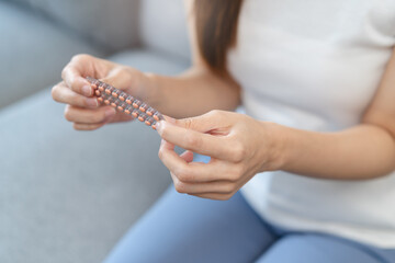 young female holding birth control pills
