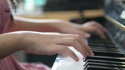 Close up on hands of a talented anonymous pianist making a masterful performance on a grand piano. Asian girl practicing songs and melody with tutor creating new music on piano as hobby at home.