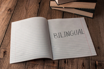 A notebook is open to a page with the word bilingual written on it