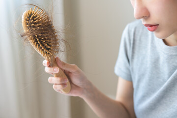 Stress asian young woman, girl hand holding comb show her hairbrush with loss, hair in brush after...
