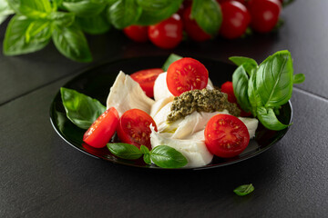 Mozzarella with basil, cherry tomatoes and pesto sauce.