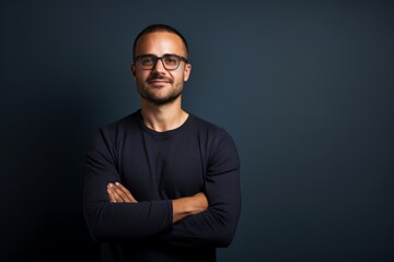 Obraz premium Portrait of a jovial man in his 30s with arms crossed isolated in plain cyclorama studio wall