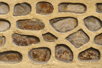 A stone wall with numerous holes throughout