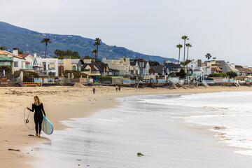 Woman Surfer Walking Along Beach in Malibu California