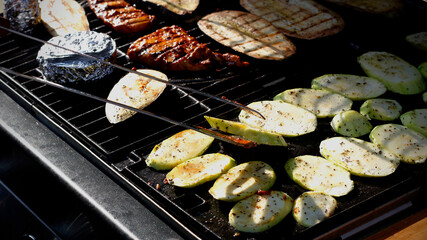 Close-up of spiced ​​zucchini, eggplant slices, cheese in foil, marinated chicken breast and...