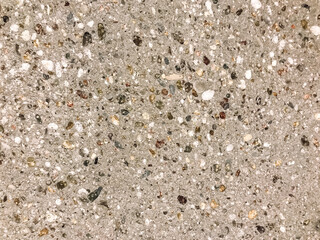 A grey and white stone surface with many small rocks scattered across it