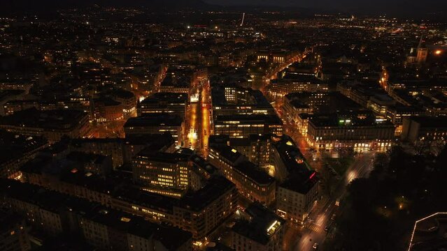Aerial view of Geneva cityscape at night, showcasing busy streets and illuminated buildings from a high perspective