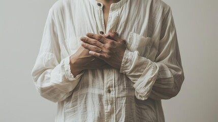 Photo of a person clutching their chest in distress against a white backdrop