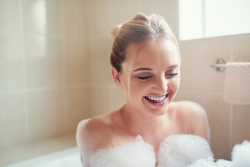 Woman, bubbles and bathroom tub with smile for hygiene, cleaning and cosmetics for skin in home....