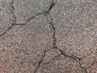Obraz premium A cracked and broken road with a lot of gravel