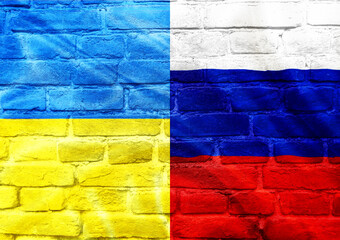 A flag with the colors blue, yellow, and red is displayed on a brick wall
