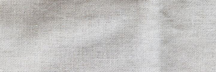 Soft light gray natural linen texture banner. Crumpled fabric background. Panoramic web header. Wide screen wallpaper.