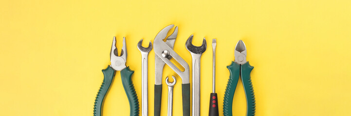 Work tools on bright yellow background banner. Panoramic web header. Wide screen wallpaper.