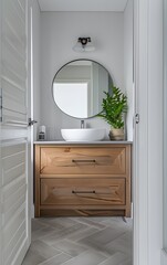 modern bathroom with herringbone tiles, oak vanity and round mirror, white walls