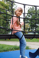 Child, monkey bars and energy on playground, smiling and obstacle course on outdoor adventure at...