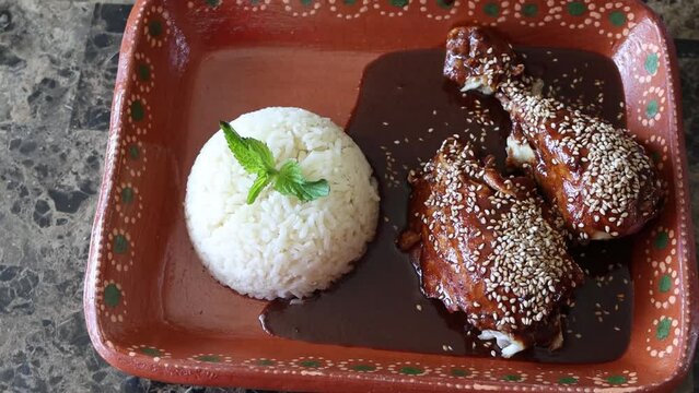 slider high view of chicken in mole sauce next to rice. Mexican food