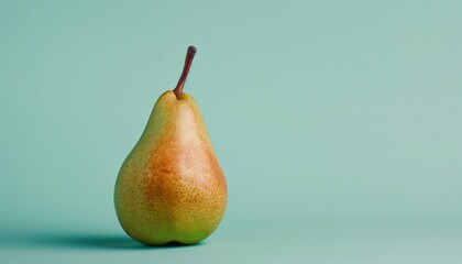 A minimalist photograph of a single ripe pear with red and green hues against a simple teal background, showcasing its natural beauty and freshness.