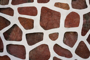 Granite wall with plaster. White cement and red natural stone texture. Rough retro surface. Vintage background for designers.