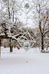 Decorations with disco ball on winter trees in the park. Snow on the branches.