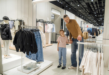 Man and Little Girl in Front of Clothing Rack