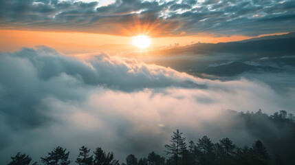 Fototapeta premium Sunrise above the clouds. Stunning sunrise over a sea of clouds with silhouettes of trees in the foreground.