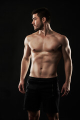 Naklejka premium Fitness, health and man shirtless for strong body, sports and cardio training isolated in studio. Male person, bodybuilder and abs from balance exercise and core workout with dark background