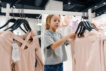 Young Girl Shopping for Clothes in Modern Retail Store During Daytime