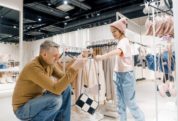 Father and Daughter Shopping for Clothing in a Modern Retail Store at Noon