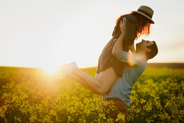 Man, lift and woman with sunset in nature for care, love and bonding for memory on field in...