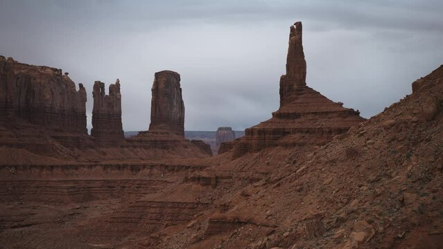 Aerial flyover view approaching Bear and Rabbit and King on his Throne rock formations / Monument Valley, Utah, United States