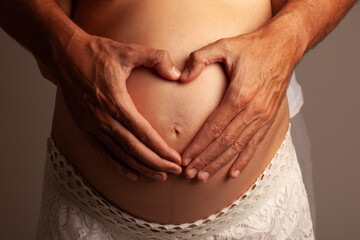 a man's hands on a pregnant woman's belly