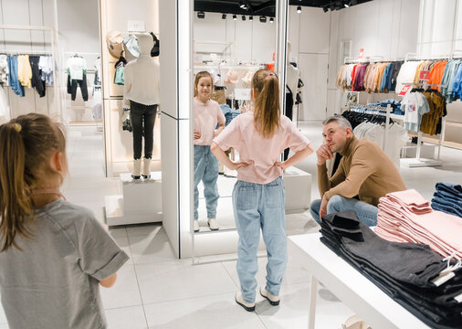 Father and Daughter Shopping for Clothes in a Stylish Boutique on a Bright Afternoon