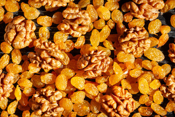 walnuts raisins on black wood background top view
