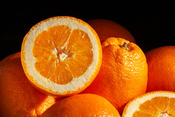 sliced calabrian oval blond oranges on black background