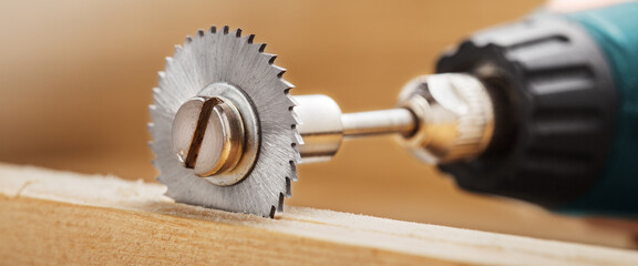 circular saw for milling machine cutting hole in wooden plank.