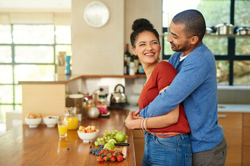 Couple, hug and kitchen with fruit breakfast for gut health nutrition in home for morning, meal or...