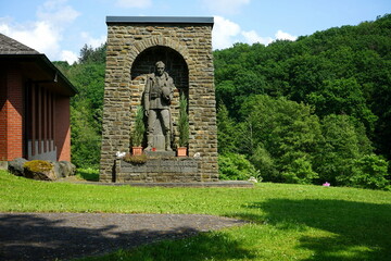 Fototapeta premium Altes Denkmal zum Gedenken an die gefallenen Soldaten der beiden Weltkriege vor blauem Himmel im Sonnenschein auf dem Friedhof in Wettenberg Krofdorf-Gleiberg bei Gießen in Hessen