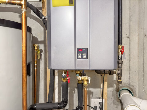 Tankless hot water heater, set to 130&deg; F,  connected to a recirculation system and storage tank