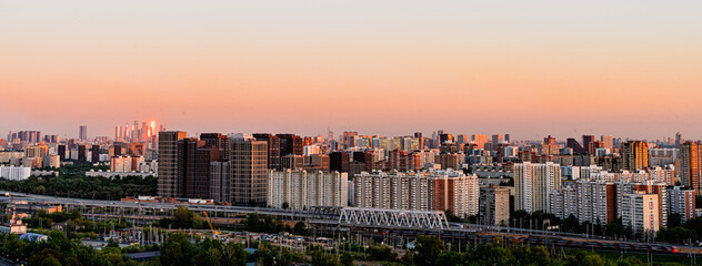 Sunset in the big city. Panorama of the residential area of the metropolis overlooking the railway....