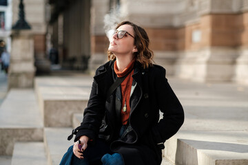 Tourist woman using e-cigarette for vaping.