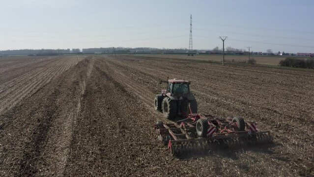 Rolnik uprawia ziemię ciągnikiem w gospodarstwie