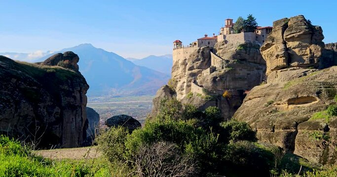 Meteora landscape with Monastery of Varlaam and the Holy Monastery of the Great Meteoron atop vertical cliffs with autumn leaves colors around, Greece.