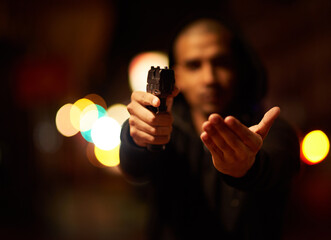 Hands, robbery and thief with gun for shooting, crime and violence outdoor in city on bokeh at...