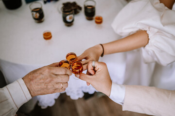 Riga, Latvia, - August 26, 2024 - Hands holding and clinking small copper mugs at a celebration.